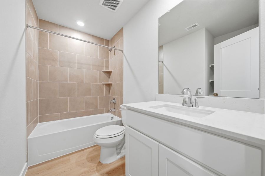 A bathroom with a tub sink and toilet. A bathroom with a tub sink and toilet.