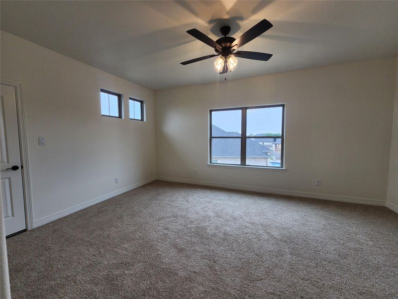 Spacious room featuring neutral carpeting, white painted walls, and a multi-pane window