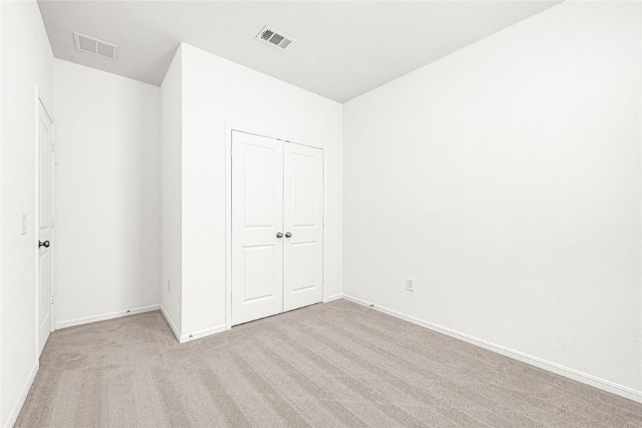 Bright bedroom or versatile flex room with clean walls and plush carpeting.