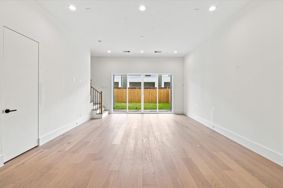 Sliding glass doors create a seamless transition from the living room to the expansive covered patio and private fenced backyard.