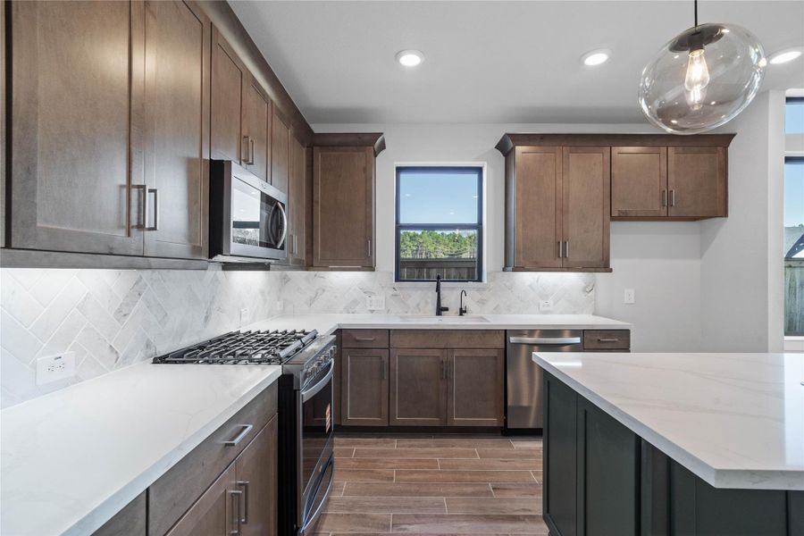 Welcome to the heart of the home, a modern, highly functional kitchen that perfectly balances style and utility. Quartz countertops, complemented by a stylish backsplash, shaker-style cabinets provide ample storage, and the Whirlpool stainless steel appliances are all features of this beautiful kitchen! Welcome to the heart of the home, a modern, highly functional kitchen that perfectly balances style and utility. Quartz countertops, complemented by a stylish backsplash, shaker-style cabinets provide ample storage, and the Whirlpool stainless steel appliances are all features of this beautiful kitchen!