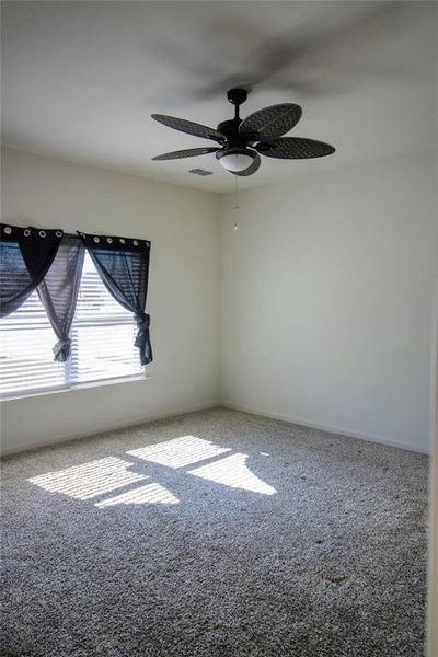 Spare room featuring carpet and a ceiling fan