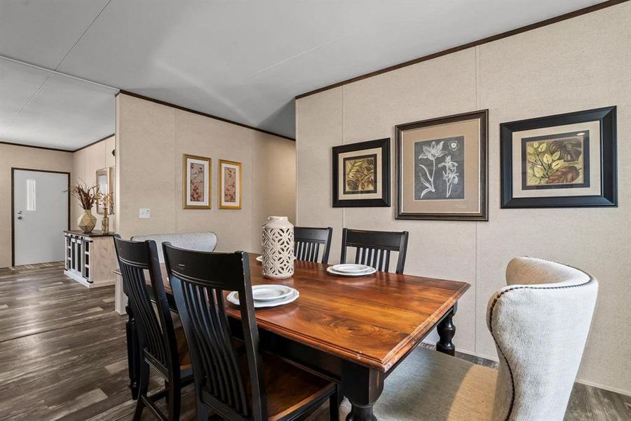 Dining space featuring dark wood-style floors and ornamental molding