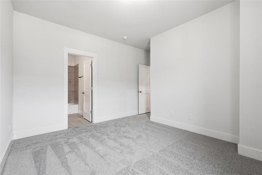 Spacious room with light gray carpeting and white baseboards