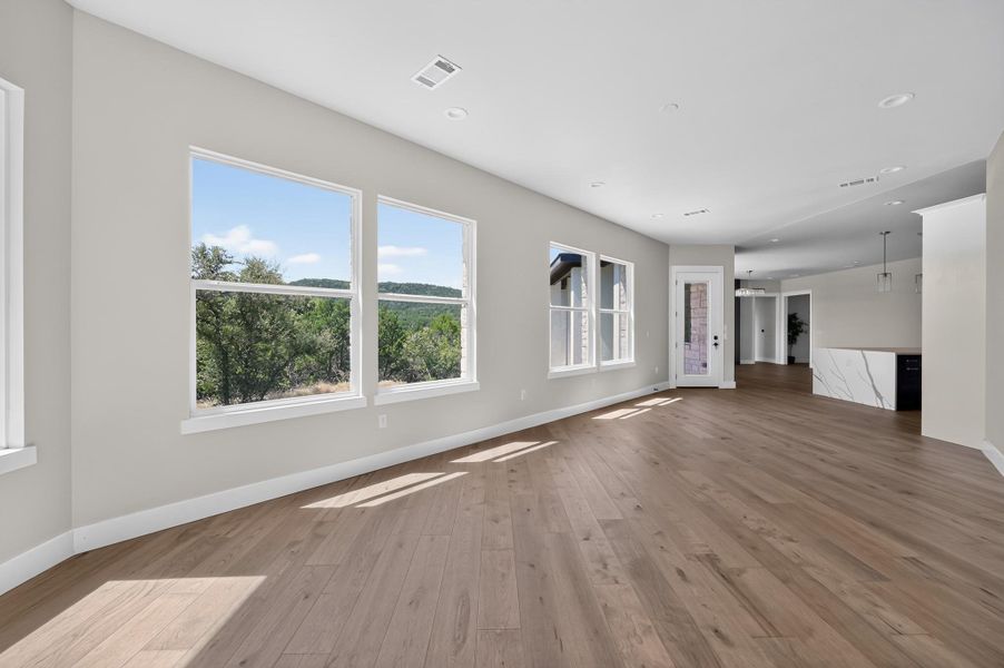 An open floorplan maximizes natural light through large windows framing scenic hill country views.