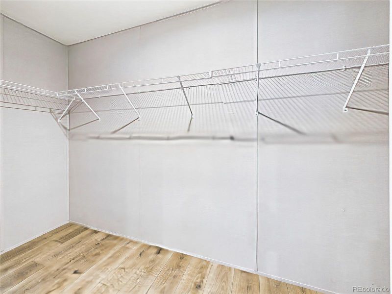 Walk-In Closet (Extended View) – Spacious walk-in closet with wraparound wire shelving, offering abundant and well-organized storage.