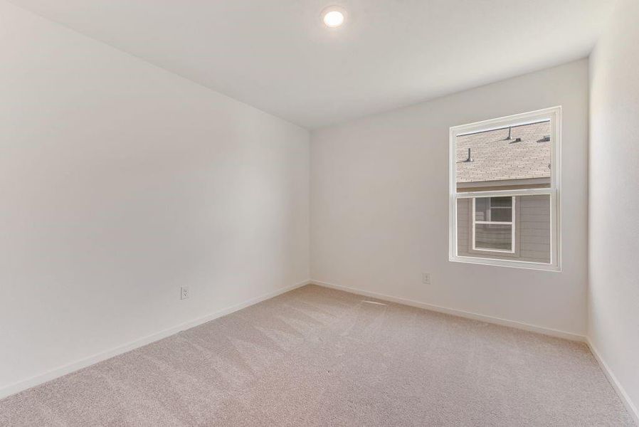 Spare room with baseboards and light colored carpet