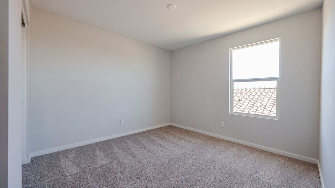 A room with a carpet and a window.