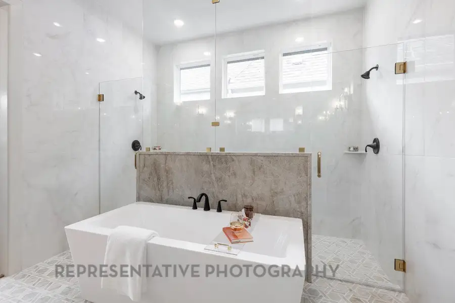 Full bathroom with a freestanding tub and a marble finish shower