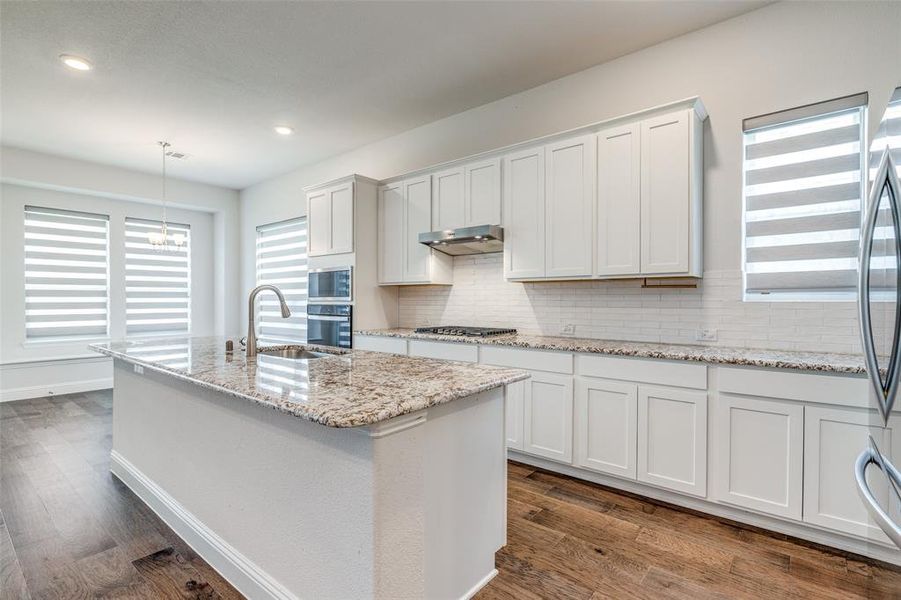 Kitchen with a sink, appliances with stainless steel finishes, plenty of natural light, decorative backsplash, and recessed lighting