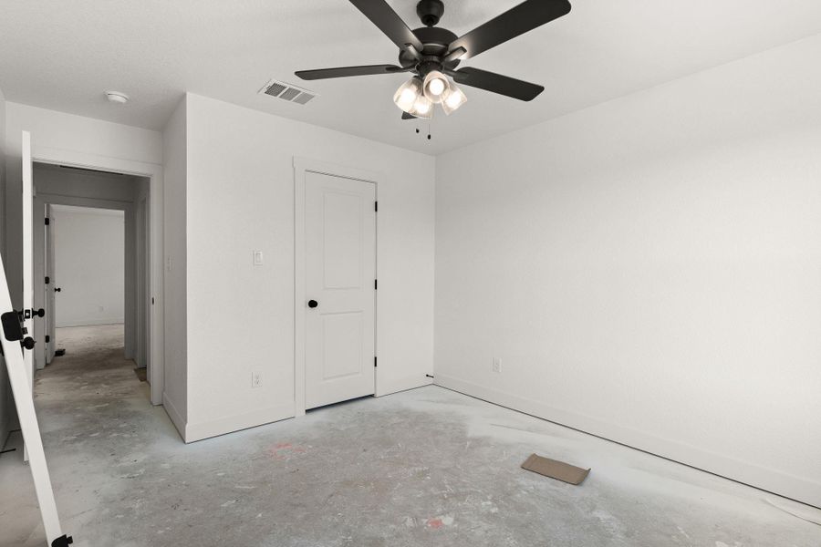 Unfurnished bedroom with concrete flooring and ceiling fan Unfurnished bedroom with concrete flooring and ceiling fan