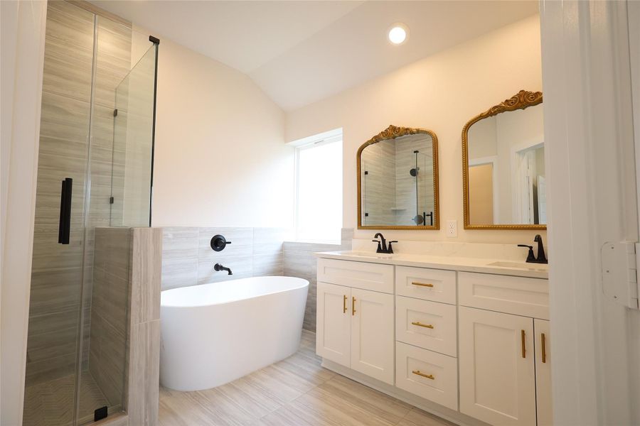 Primary en-suite bathroom with separate standing shower and large soaking tub.