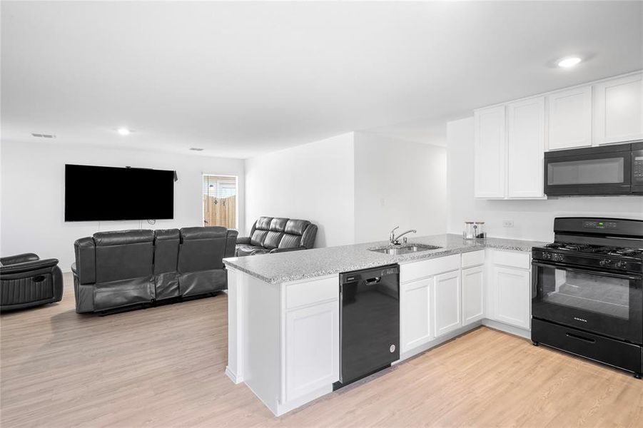 Open-concept living area with wood-finish flooring Open-concept living area with wood-finish flooring
