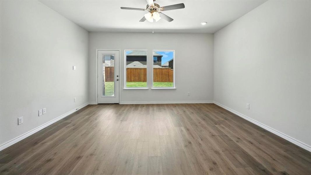 Spare room featuring dark wood-style flooring and ceiling fan