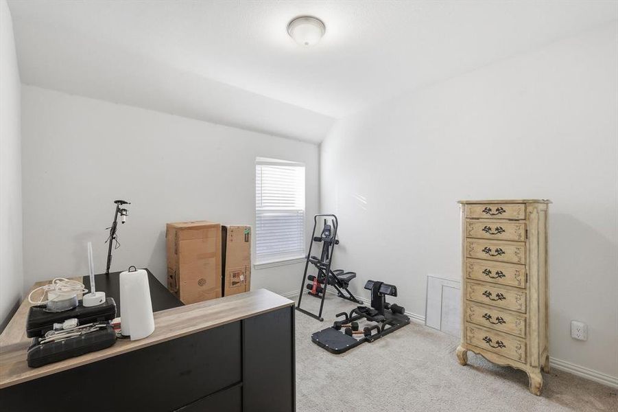 Exercise room with light colored carpet and lofted ceiling