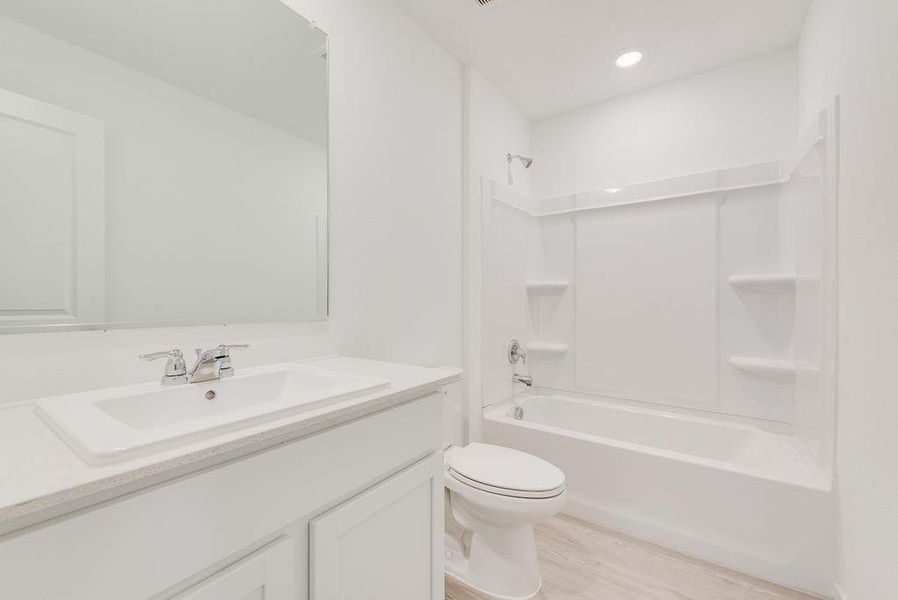 Full bathroom featuring vanity, toilet, bathing tub / shower combination, and wood-type flooring