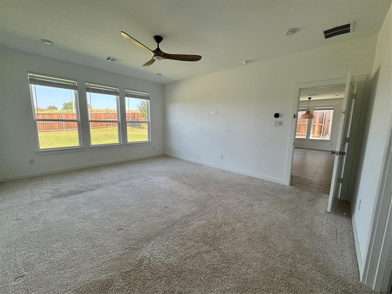 Primary bedroom featuring carpet floors and ceiling fan Primary bedroom featuring carpet floors and ceiling fan