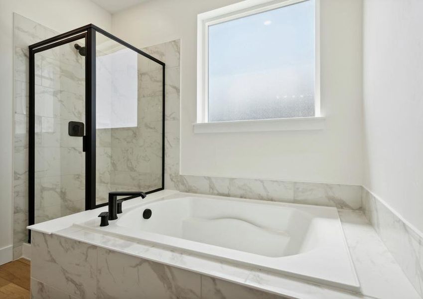 The master bathroom has a large glass, walk-in shower and garden tub.