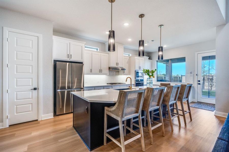 Kitchen featuring white cabinetry, appliances with stainless steel finishes, light wood-style flooring, plenty of natural light, and recessed lighting