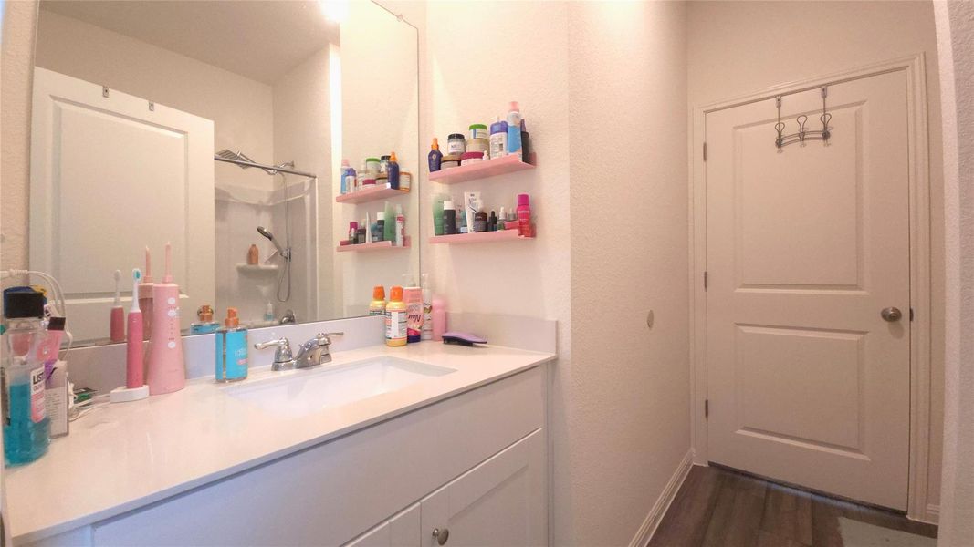 Bathroom vanity with an integrated rectangular sink, chrome faucet, and expansive mirror