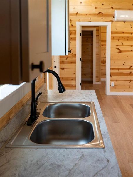 Kitchen view of light wood finished floors and a wall unit AC Kitchen view of light wood finished floors and a wall unit AC