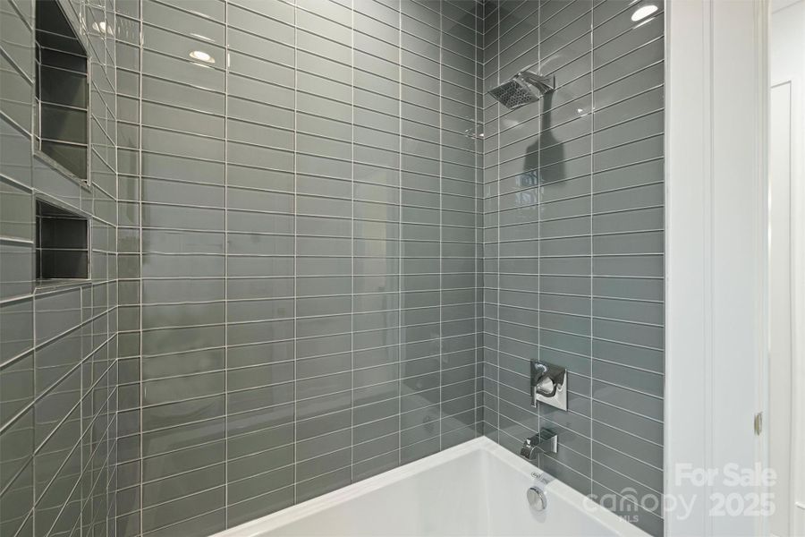 Third full bath on second level features designer tile selections.