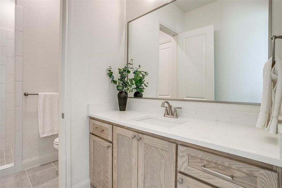 Bathroom featuring tile  floors, a shower, vanity, and toilet