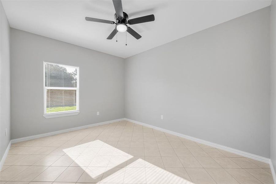 Tiled spare room with ceiling fan