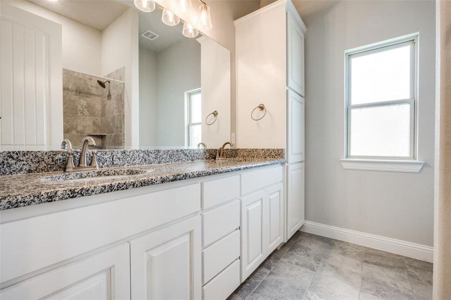 Bathroom with tile patterned flooring and dual bowl vanity