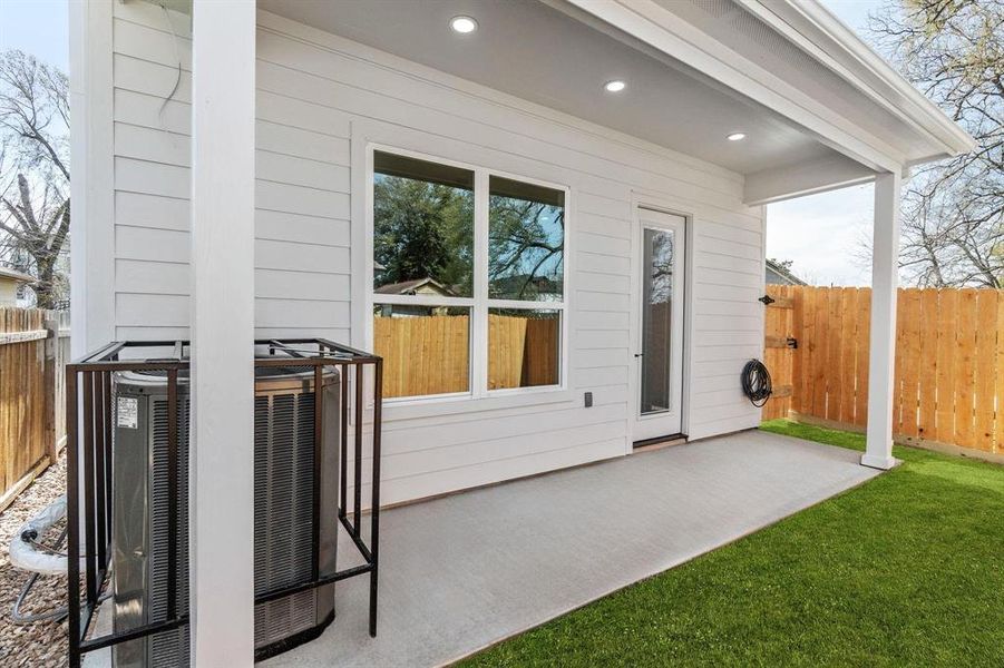 Backyard showcasing a stunning patio with a dramatic soaring roofline.