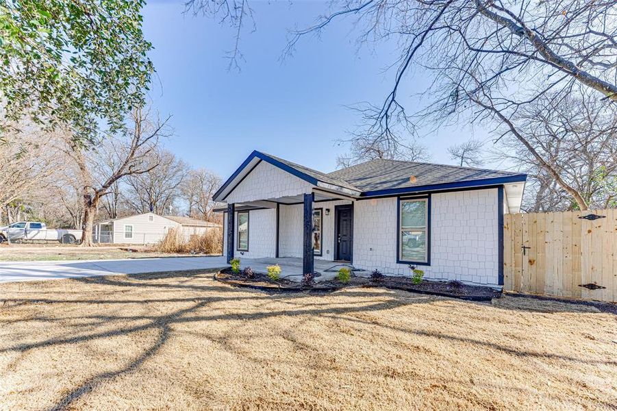 View of front of home with covered porch and a front yard