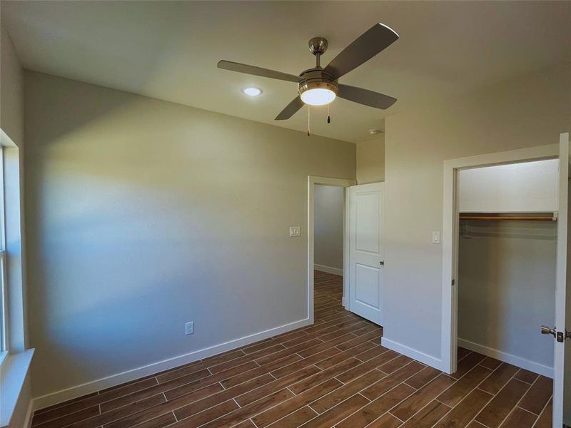 Unfurnished bedroom with ceiling fan and a closet