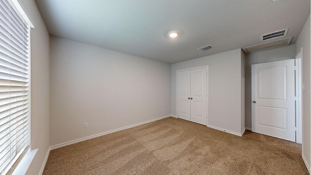 Carpeted interior room featuring a window with white horizontal blinds, light gray wall paint, white baseboards, and a recessed ceiling light Carpeted interior room featuring a window with white horizontal blinds, light gray wall paint, white baseboards, and a recessed ceiling light