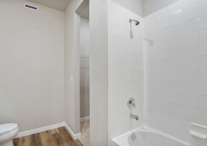 The master bathroom has a large vanity and a step in shower and soaking tub.