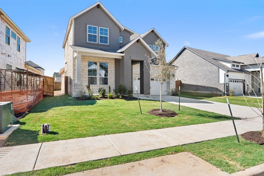 Front exterior of a new home in Persimmon, Buda, TX, highlighting curb appeal (Image 24). Front exterior of a new home in Persimmon, Buda, TX, highlighting curb appeal (Image 24).