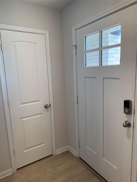 Doorway with wood finished floors and baseboards