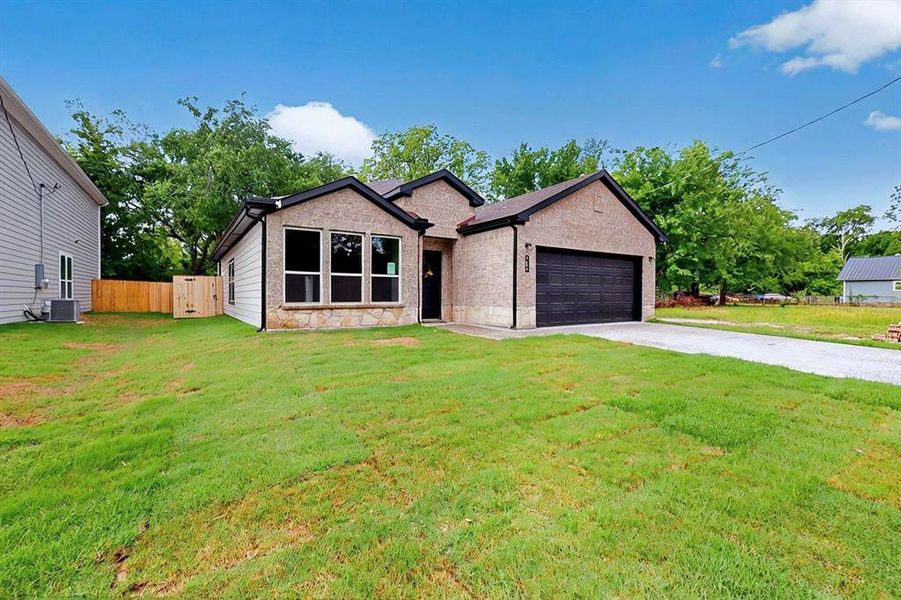 View of front of house featuring a garage, fence, cooling unit, a front lawn, and stone siding View of front of house featuring a garage, fence, cooling unit, a front lawn, and stone siding