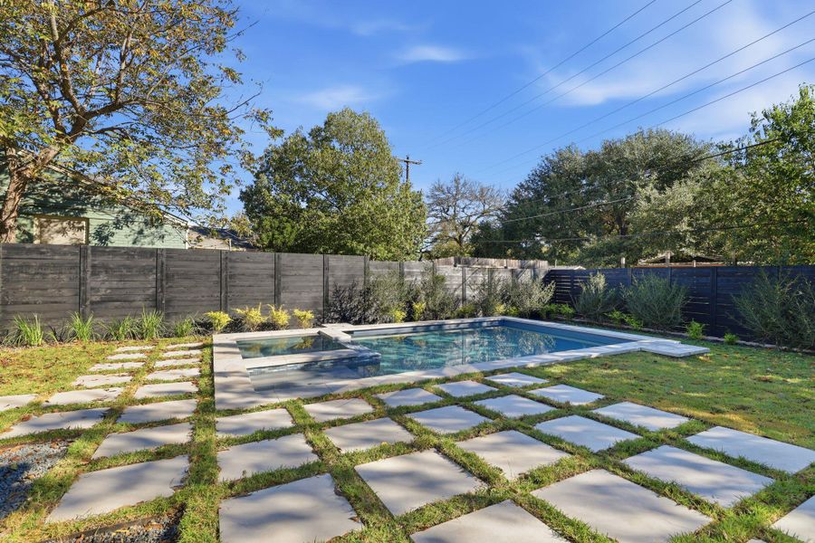 View of pool with a fenced backyard, a pool with connected hot tub, and a patio area