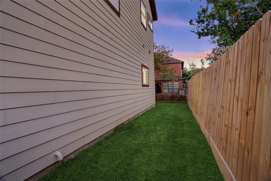 Long, fully fenced side yard ideal for pets, gardening, or added outdoor space.