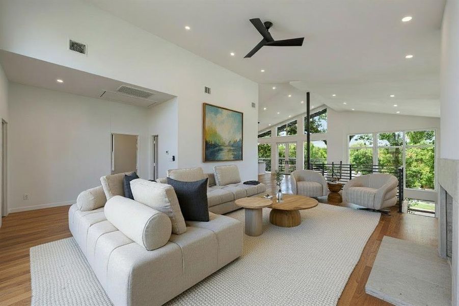 Living room featuring high vaulted ceiling, recessed lighting, wood finished floors, and a ceiling fan