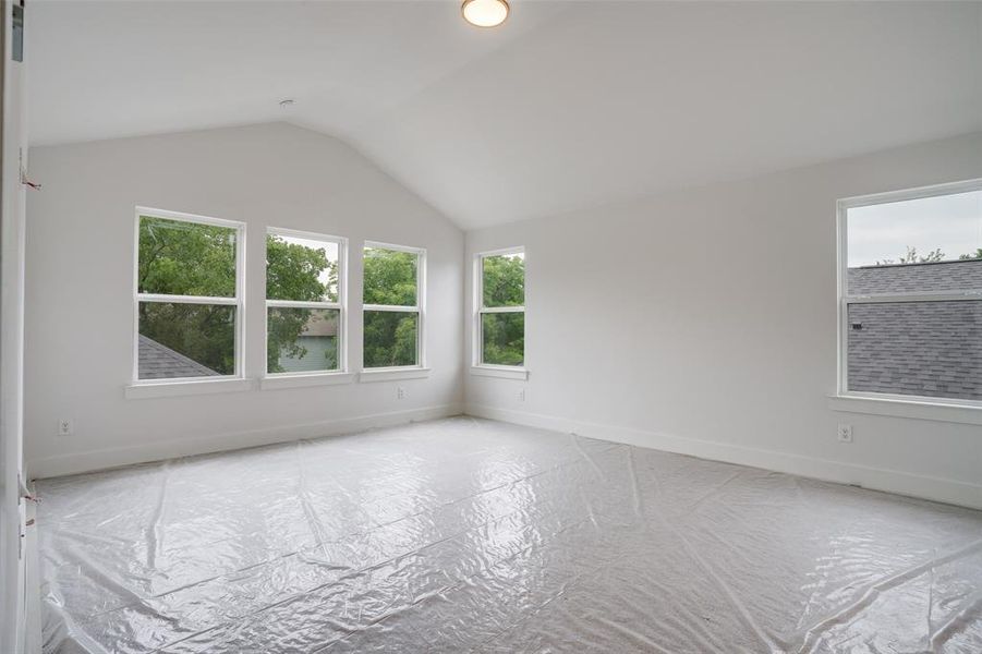 Empty room featuring vaulted ceiling