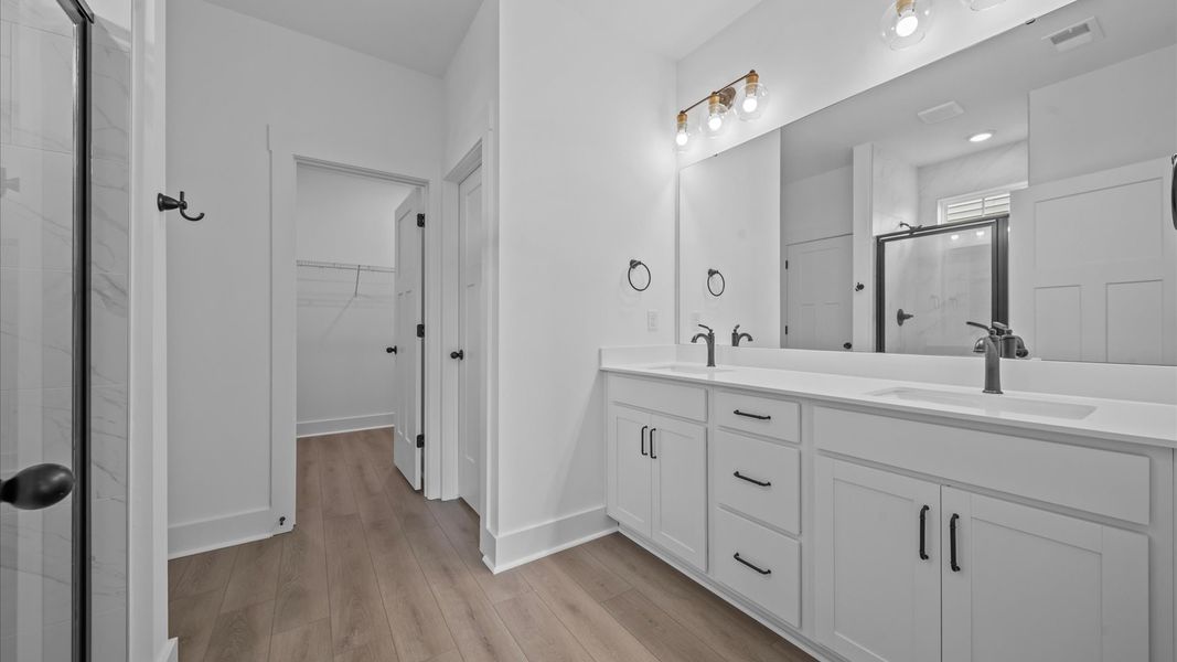 Tasteful primary bath with modern finishes, a tiled walk-in shower, and thoughtful double vanity layout Tasteful primary bath with modern finishes, a tiled walk-in shower, and thoughtful double vanity layout