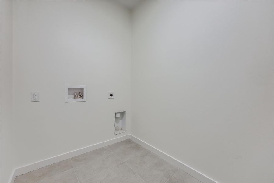 Laundry area with electric dryer hookup, washer hookup, and light tile patterned floors Laundry area with electric dryer hookup, washer hookup, and light tile patterned floors