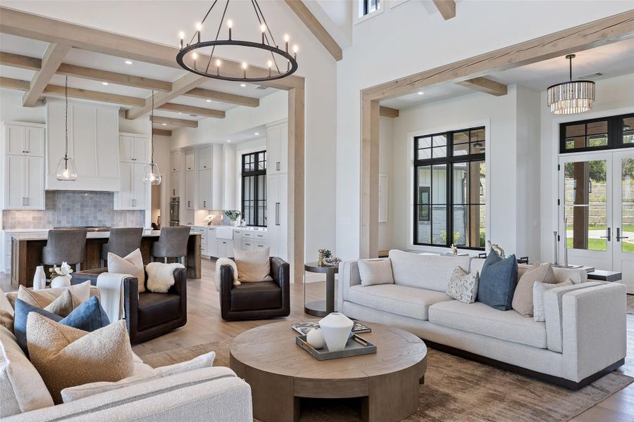 Living room featuring beamed ceiling, a chandelier, wood finished floors, recessed lighting, and a towering ceiling
