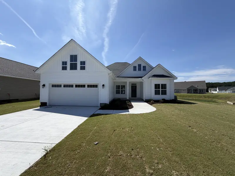 Front exterior of a new home in The Villas at Langston Farms, Winterville, NC, highlighting curb appeal (Image 1). Front exterior of a new home in The Villas at Langston Farms, Winterville, NC, highlighting curb appeal (Image 1).