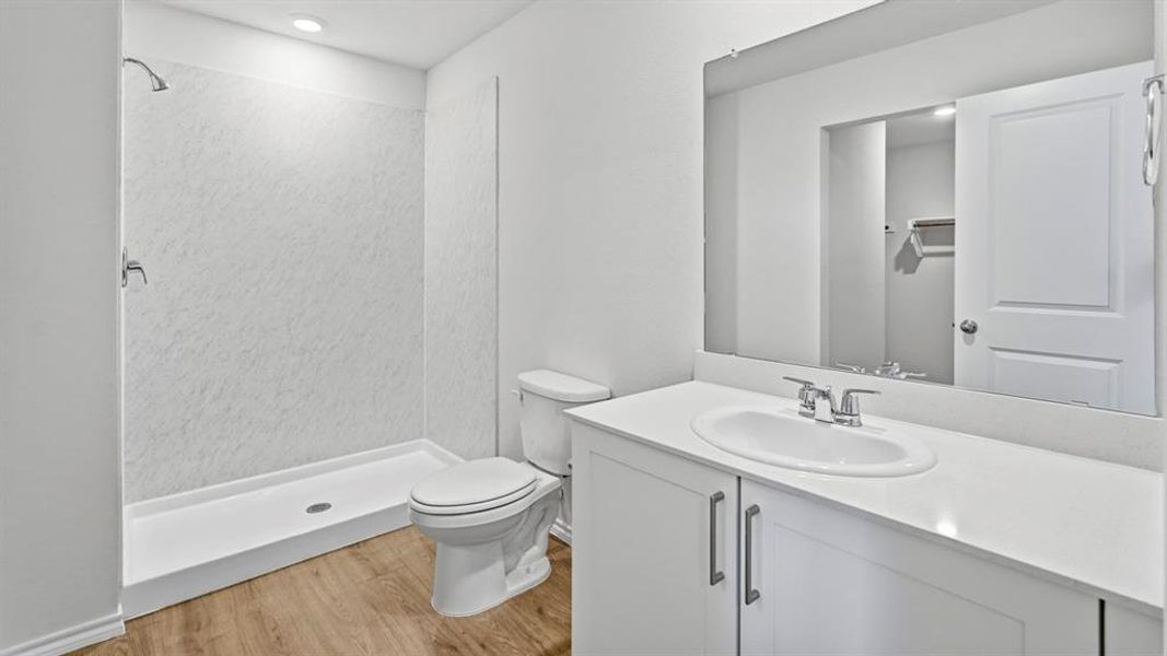 Full bath featuring vanity, light wood-style flooring, a shower stall, and recessed lighting