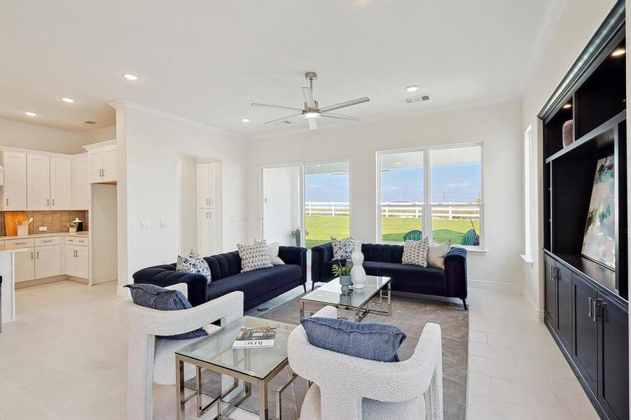 Tiled living room featuring crown molding and ceiling fan