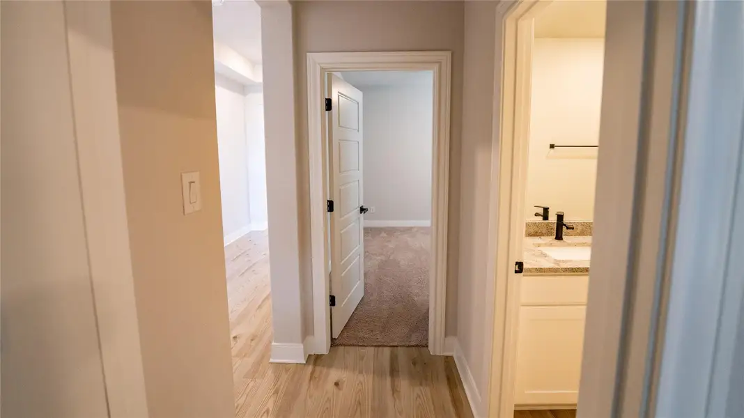 Hallway featuring light wood-style flooring and baseboards Hallway featuring light wood-style flooring and baseboards