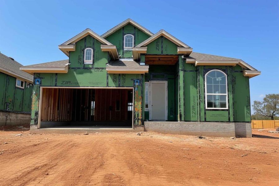 Property under construction featuring dirt driveway, an attached garage, and roof with shingles Property under construction featuring dirt driveway, an attached garage, and roof with shingles