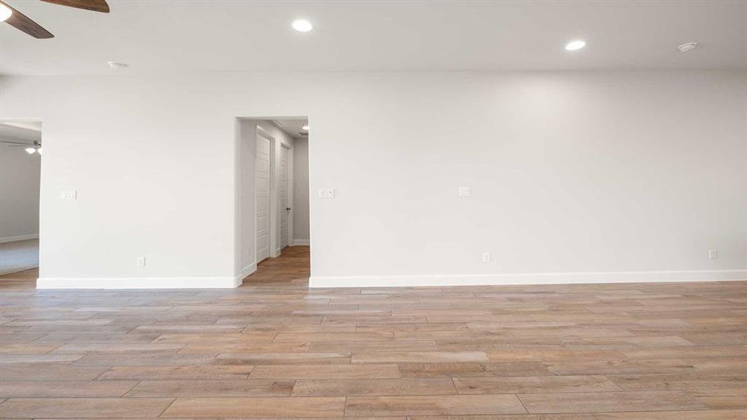 Empty room featuring light wood-type flooring and ceiling fan